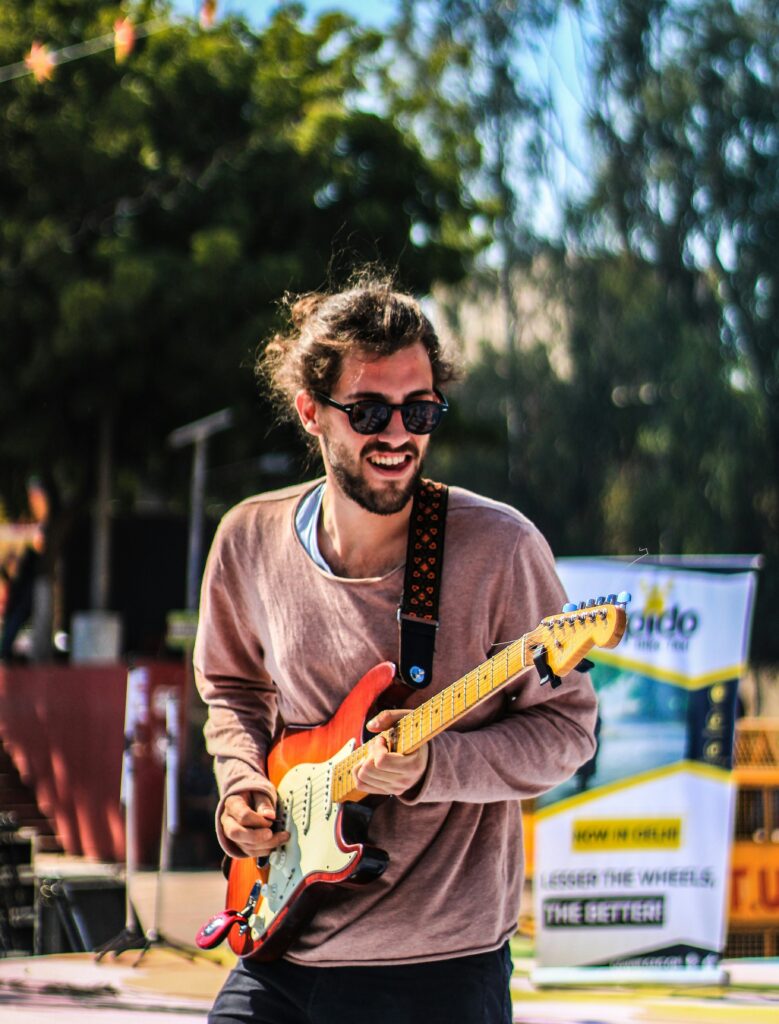 Person having fun playing the electric guitar outside