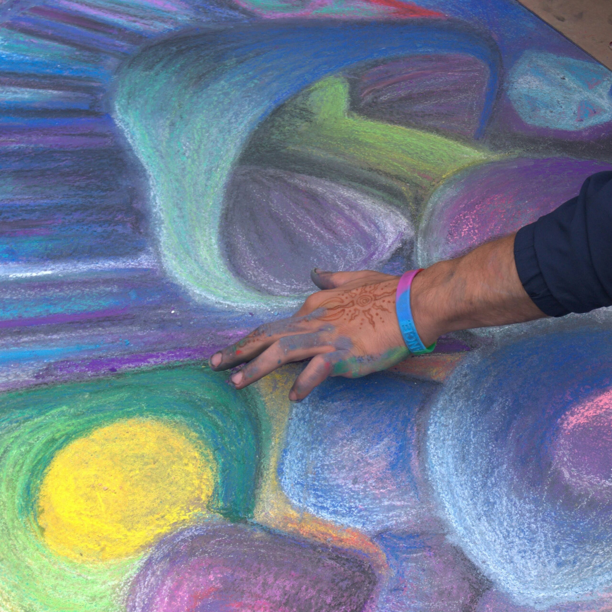 An abstract, colourful artwork being created with fingers